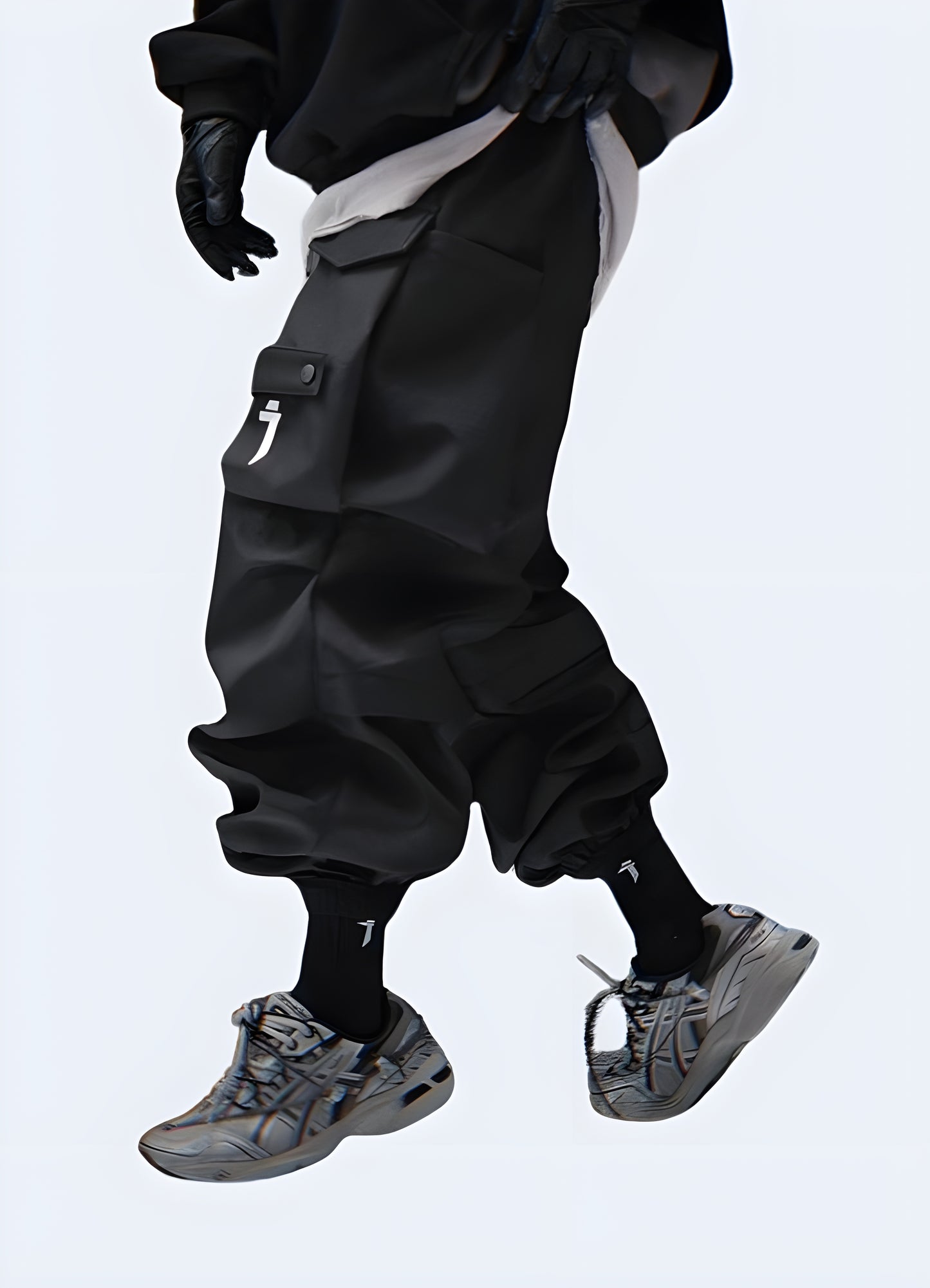 The pants feature a slim, tapered fit with a matte black finish and multiple utilitarian pockets.