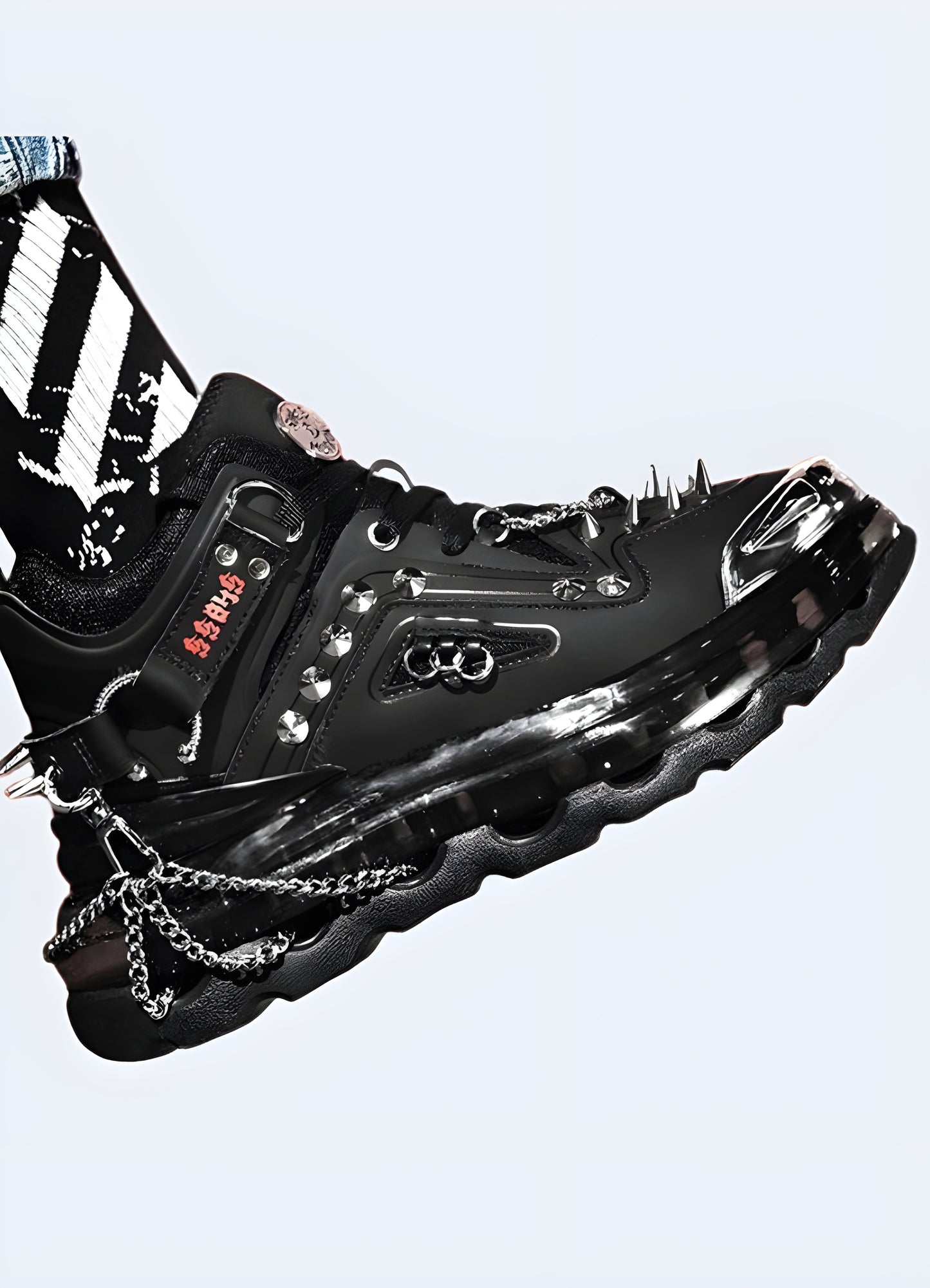  Adorned with menacing metal spikes and integrated chains, black goth sneakers.