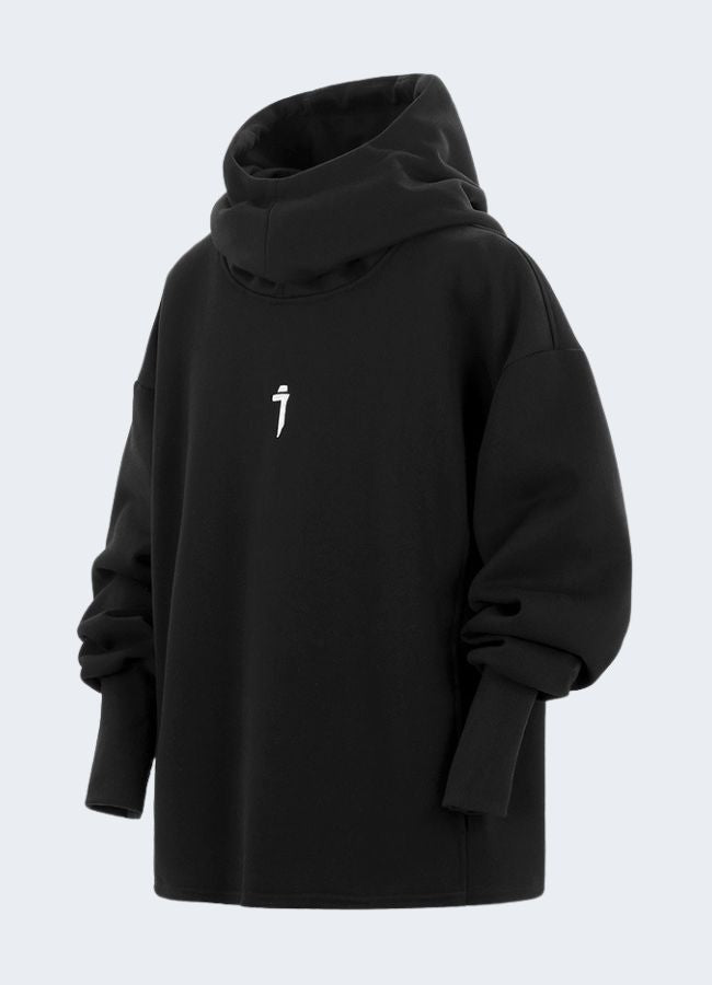 Side view of a model wearing a black hoodie, showcasing streetwear fashion. The hoodie features a modern, minimalist design with slits on the sides and the model's hands in the pockets.