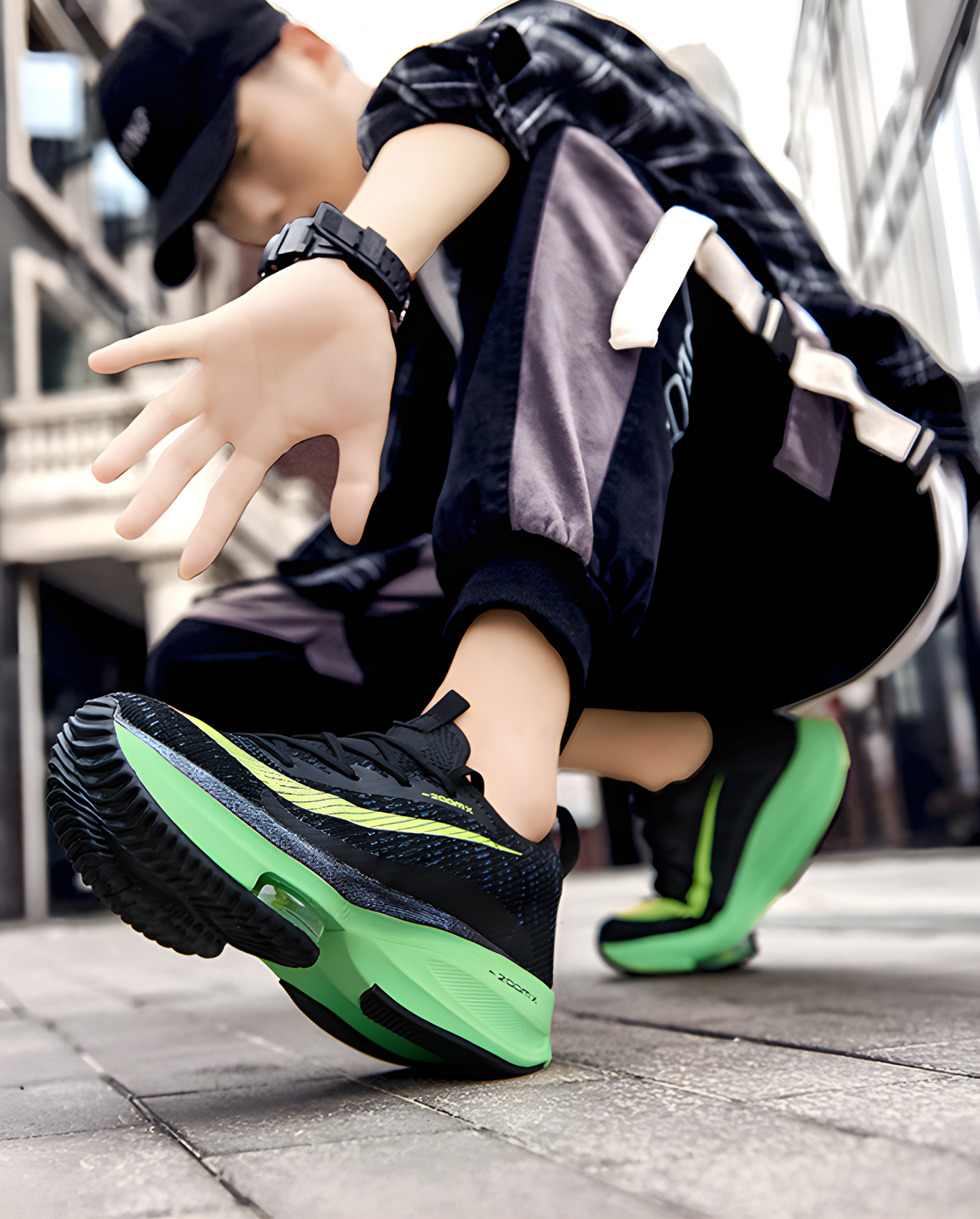 A side view of black tech shoes featuring green accents, modeled to highlight their modern design and functionality.