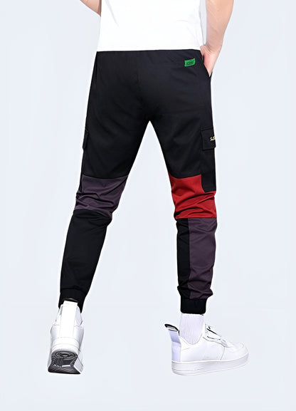 Man wearing red techwear pants, showcasing a sleek and functional design, front and side view. These pants offer a bold yet practical look, perfect for modern streetwear enthusiasts who appreciate both style and utility in their wardrobe. Ideal for those looking to make a statement in contemporary urban fashion.