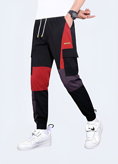 Man wearing red techwear pants, showcasing a sleek and functional design, front and side view. These pants offer a bold yet practical look, perfect for modern streetwear enthusiasts who appreciate both style and utility in their wardrobe. Ideal for those looking to make a statement in contemporary urban fashion.