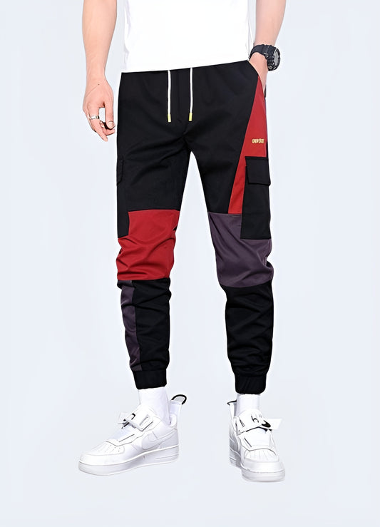 Man wearing red techwear pants, showcasing a sleek and functional design, front and side view. These pants offer a bold yet practical look, perfect for modern streetwear enthusiasts who appreciate both style and utility in their wardrobe. Ideal for those looking to make a statement in contemporary urban fashion.