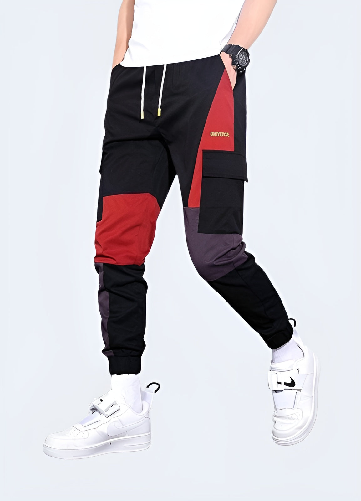 Man wearing red techwear pants, showcasing a sleek and functional design, front and side view. These pants offer a bold yet practical look, perfect for modern streetwear enthusiasts who appreciate both style and utility in their wardrobe. Ideal for those looking to make a statement in contemporary urban fashion.