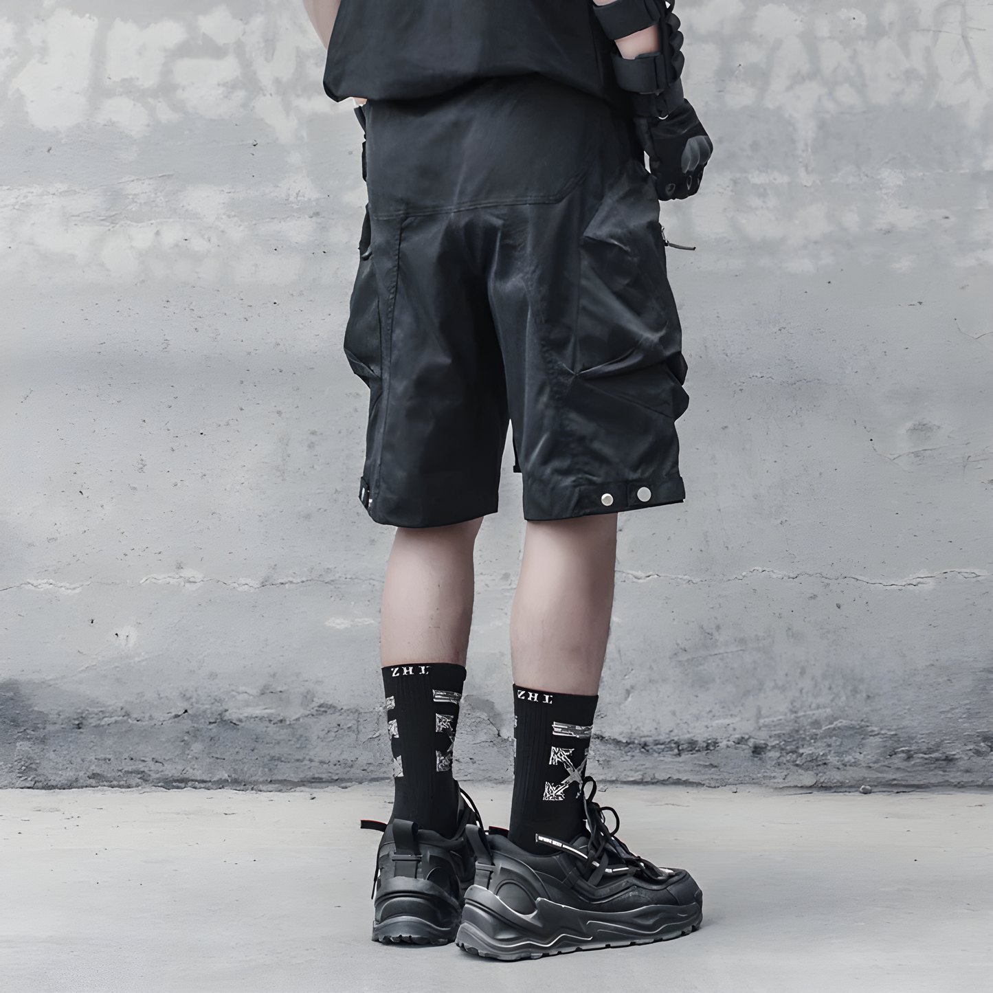 Man wearing technical shorts in black, back view, showcasing the sleek and functional design perfect for modern techwear enthusiasts in the AU.