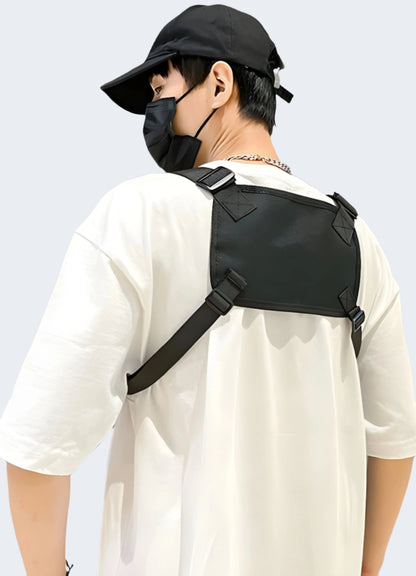 The chest bag, positioned comfortably across his back and chest, features multiple compartments and a sleek, modern design suitable for urban settings.