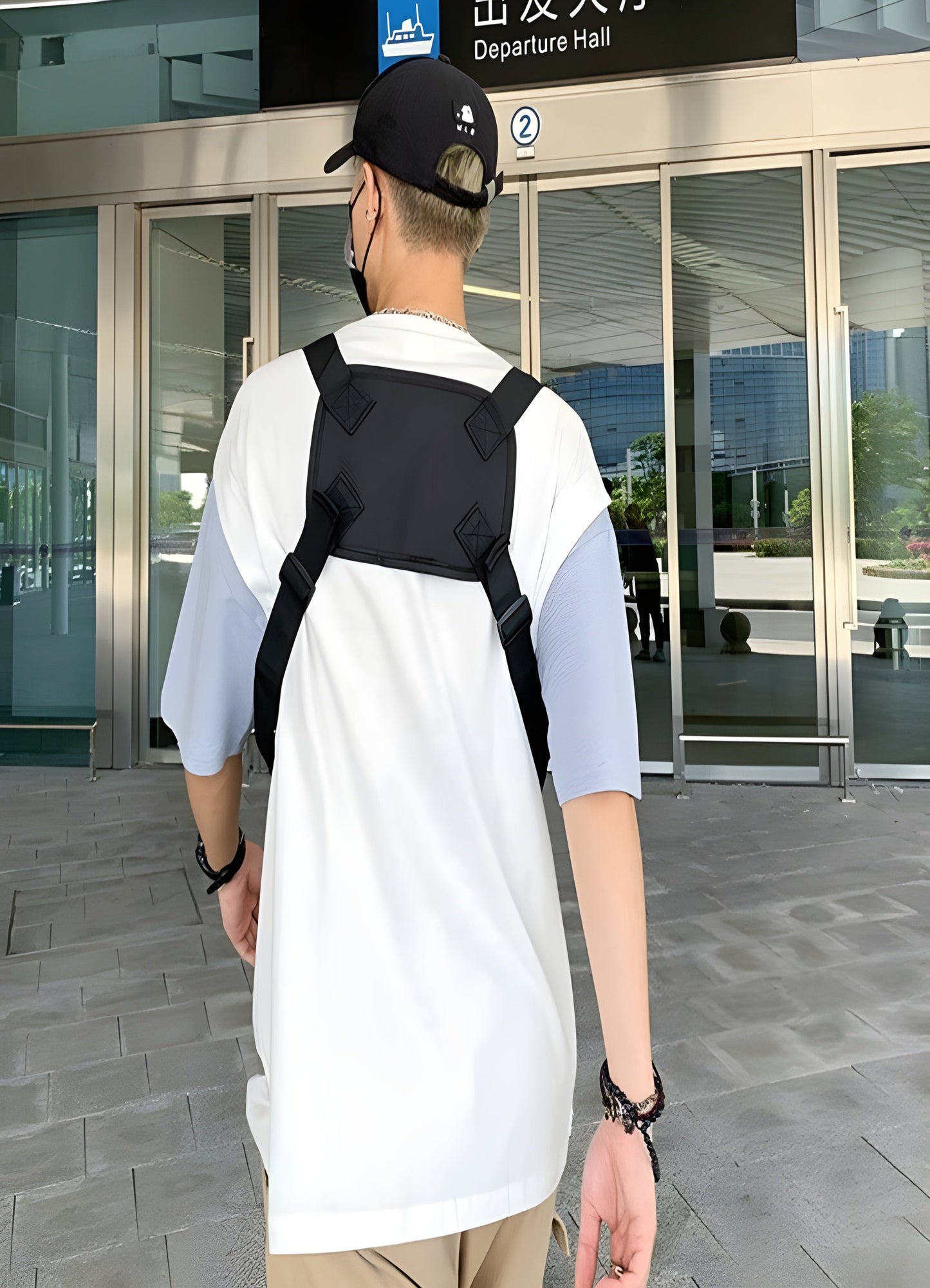 A back view of a male model showcasing a chest utility bag, highlighting its ergonomic design with multiple compartments and adjustable straps for versatile use, emphasizing both functionality and fashion.