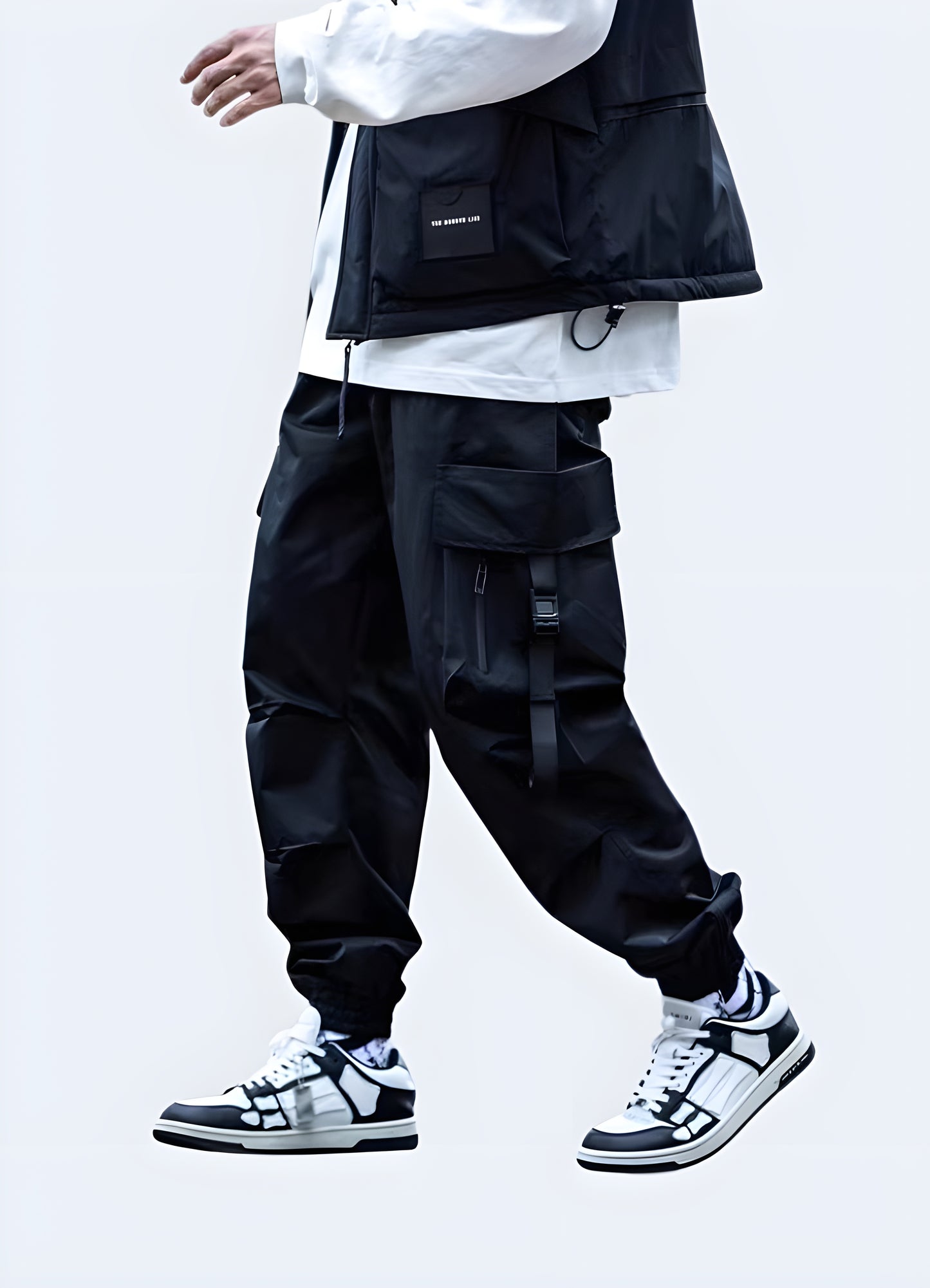 Man wearing black Japanese techwear cargo pants with multiple pockets and straps, front view, AU style.