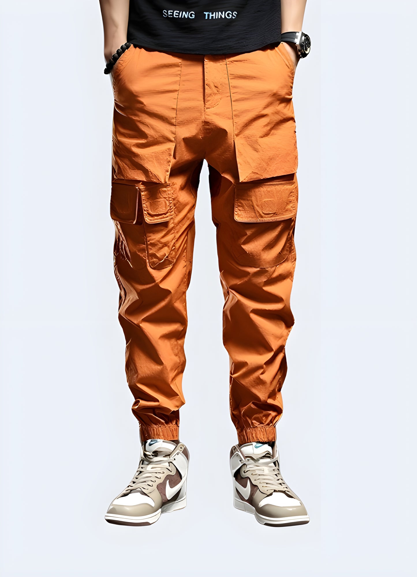 Futuristic orange techwear pants men wearing front view.
