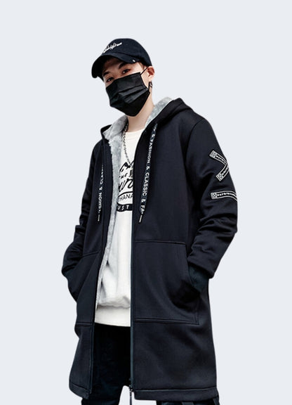 A stylish model confidently sports an oversized streetwear coat with a hood.