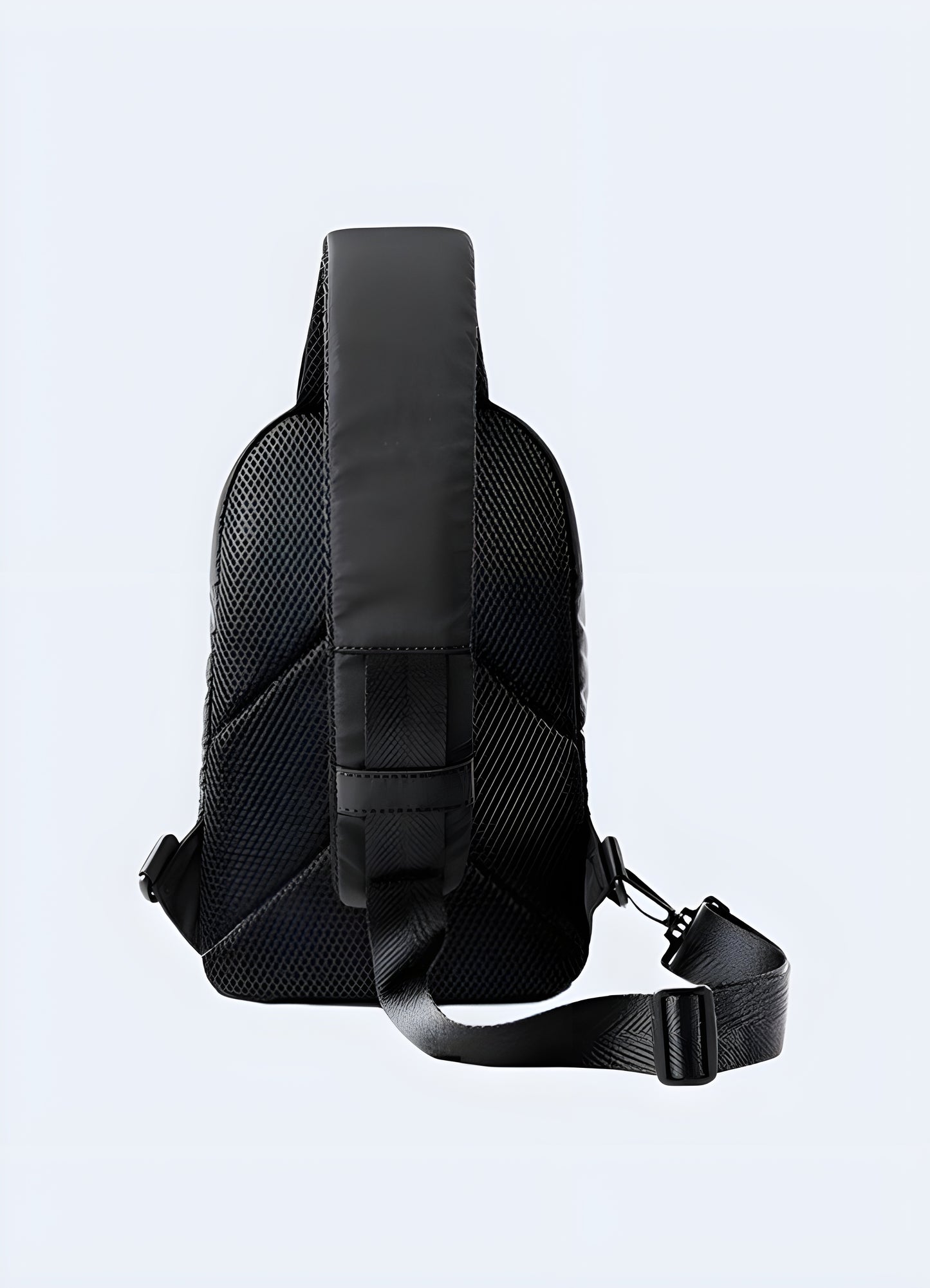 Man wearing a small black sling bag on his back, featuring an urban techwear design. The adjustable strap ensures a secure fit, while the sleek and minimalistic style makes it ideal for everyday use in the UK.