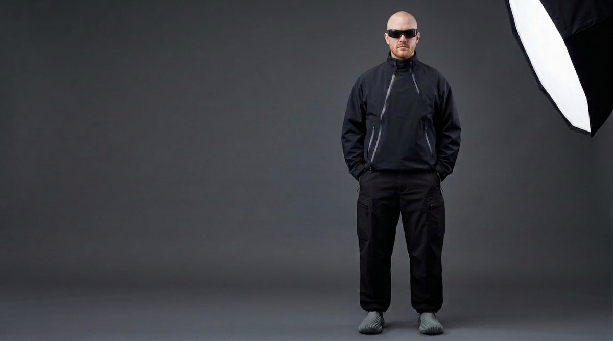 Person wearing a black outfit against a gray background